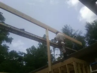 Carpenter setting a ridge beam over a new addition frame — Ice Dam Removal by Roofing Brothers in Federalsburg