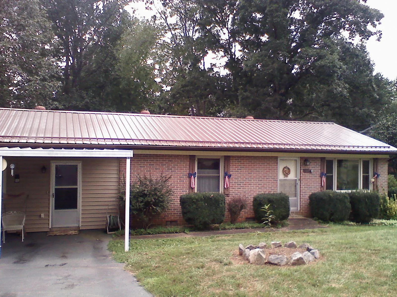 Bronze metal roof and carport on a brick ranch home — Roof Repair work by our crew in Federalsburg